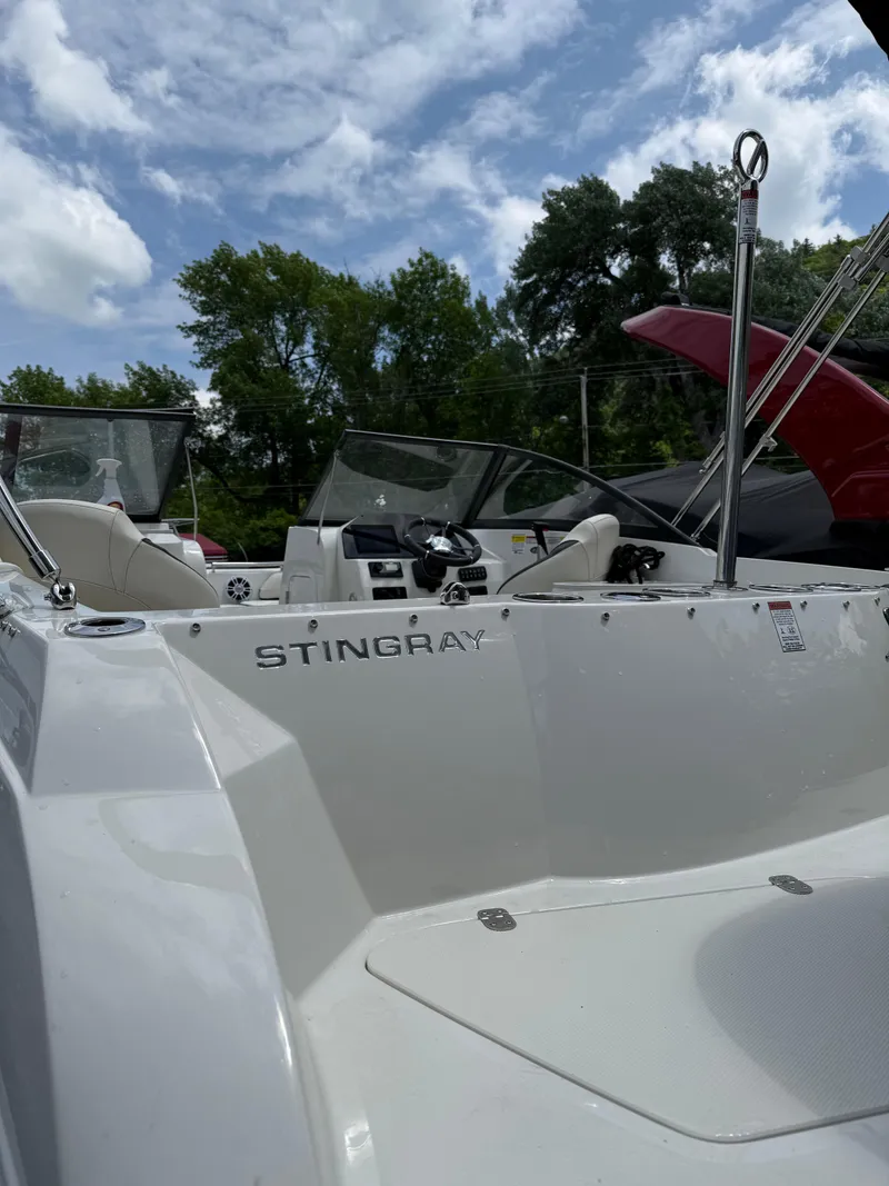 Slide: The Image of 2024 Stingray 201DC boat with sleek design, white exterior, and open cockpit under a blue sky. - 7