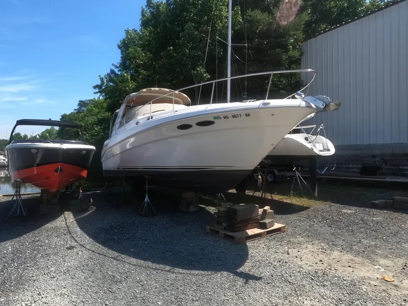 Slide: The Image of 2001 Sea Ray 340 Sundancer boat on dry dock next to another boat. - 0