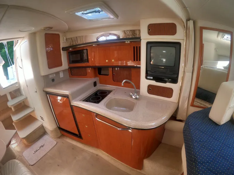Slide: The Image of 2001 Sea Ray 340 Sundancer galley with sink, stove, microwave, and TV. - 11