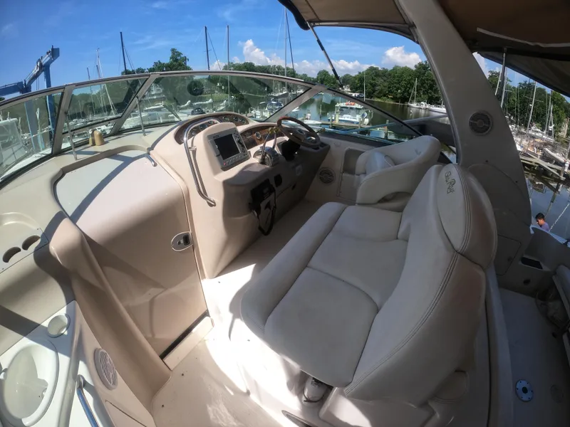 Slide: The Image of 2001 Sea Ray 340 Sundancer cockpit with helm and seating, docked at marina. - 7