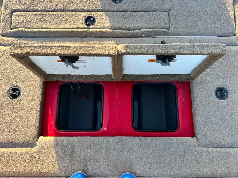 Slide: The Image of 2004 Stratos 201 Pro XL boat storage compartments with open lids and red interior. - 11