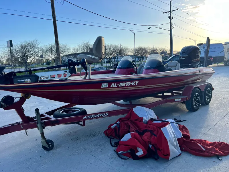 Slide: The Image of 2004 Stratos 201 Pro XL boat on trailer with red cover, parked outdoors. - 4
