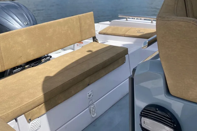 Slide: The Image of 2025 Ranieri Cayman 23.0 Sport Touring boat interior with tan seating and water backdrop. - 11