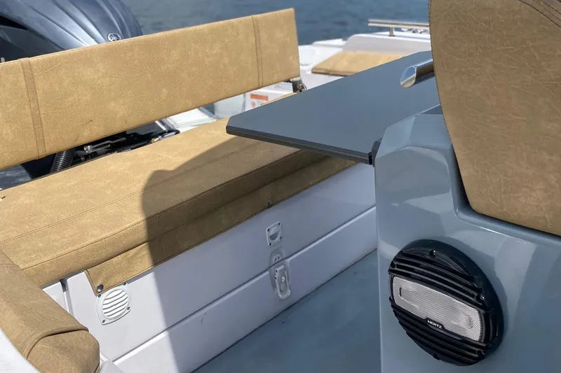 Slide: The Image of 2025 Ranieri Cayman 23.0 Sport Touring boat interior with beige seating and table. - 12