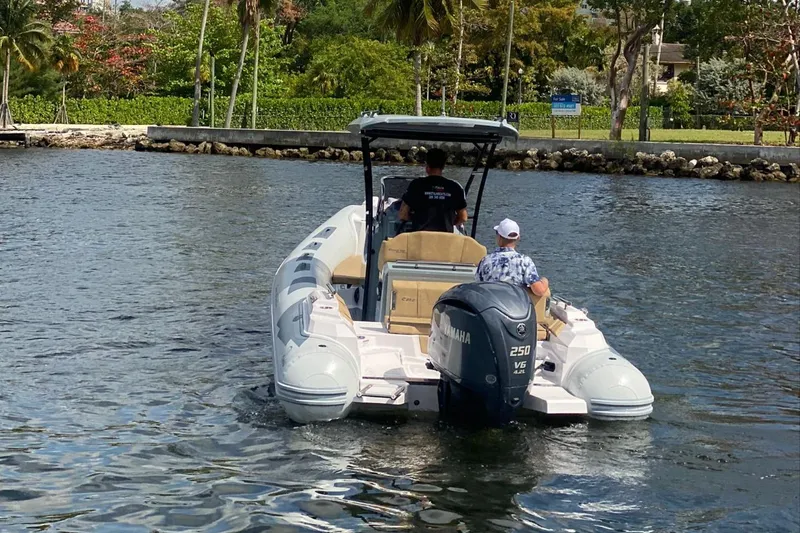 Slide: The Image of 2025 Ranieri Cayman 23.0 Sport Touring boat cruising on a calm waterway. - 2