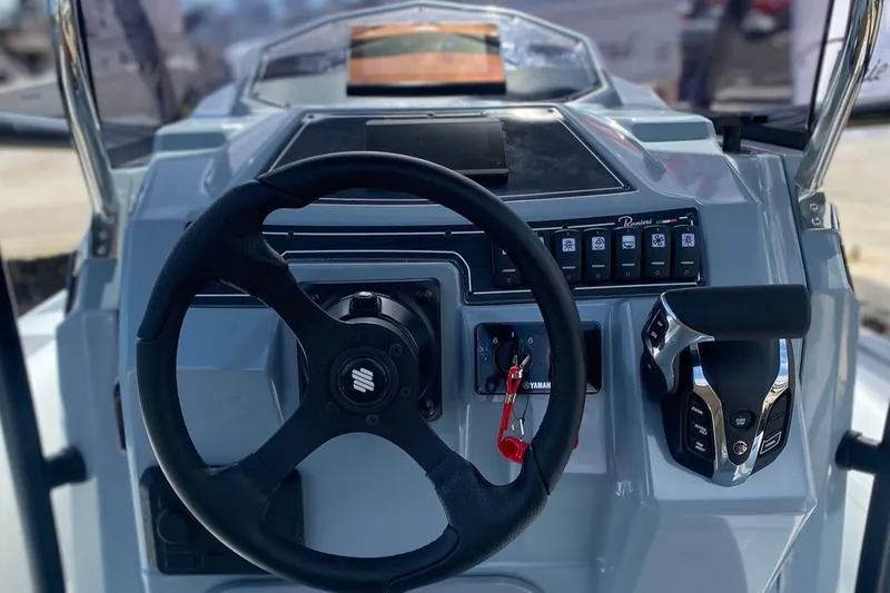 Slide: The Image of 2025 Ranieri Cayman 23.0 Sport Touring boat dashboard with steering wheel and control panel. - 6