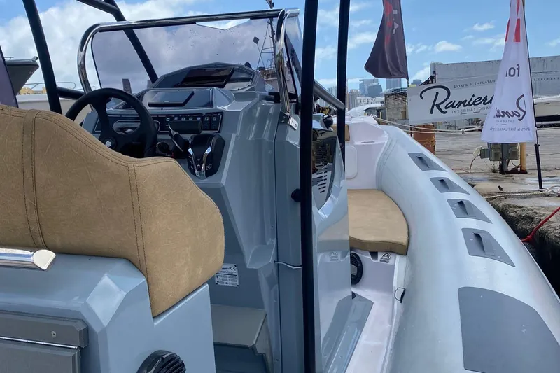 Slide: The Image of 2025 Ranieri Cayman 23.0 Sport Touring boat interior with steering wheel and seating. - 7