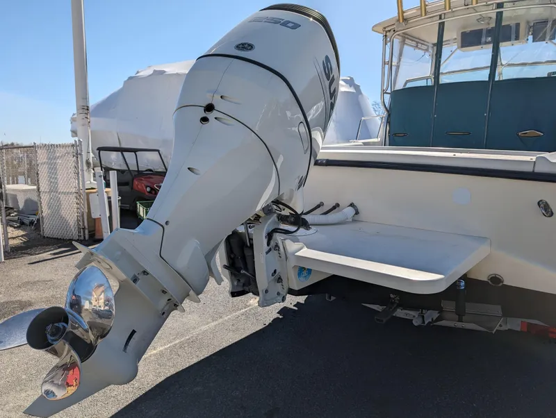Slide: The Image of 1999 Parker 2510 Walkaround boat with outboard motor in a marina. - 13