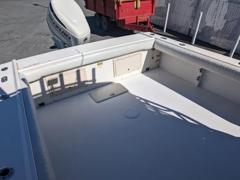 Slide: The Image of 1999 Parker 2510 Walkaround boat deck with storage compartments and outboard motor. - 15