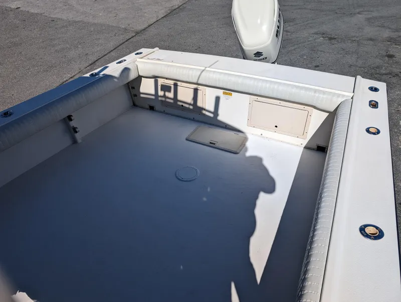 Slide: The Image of 1999 Parker 2510 Walkaround boat deck with cushioned seating and storage compartments. - 16