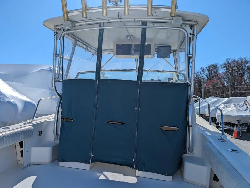 Slide: The Image of 1999 Parker 2510 Walkaround boat with blue canvas enclosure. - 17