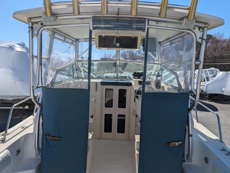 Slide: The Image of 1999 Parker 2510 Walkaround boat cockpit with blue canvas covers. - 19