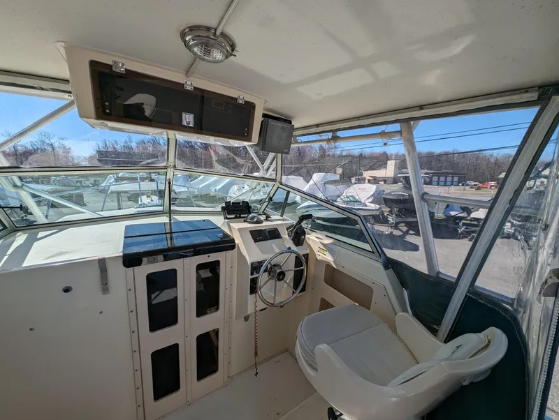 Slide: The Image of 1999 Parker 2510 Walkaround boat cockpit with steering wheel and navigation equipment. - 20
