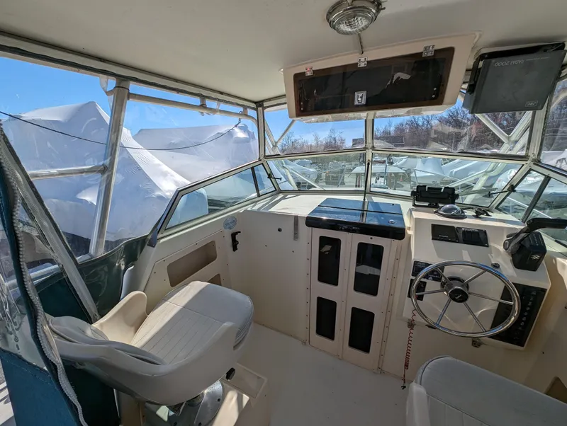 Slide: The Image of 1999 Parker 2510 Walkaround boat cockpit with steering wheel and seating. - 21