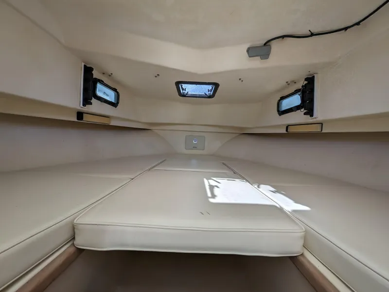 Slide: The Image of Interior cabin of a 1999 Parker 2510 Walkaround boat with beige cushions. - 28