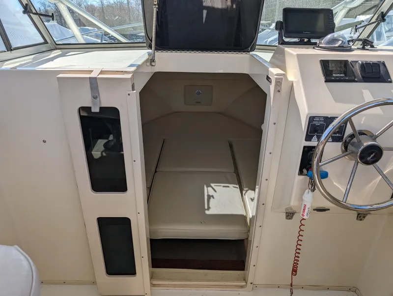 Slide: The Image of 1999 Parker 2510 Walkaround boat interior with cabin and helm station. - 29