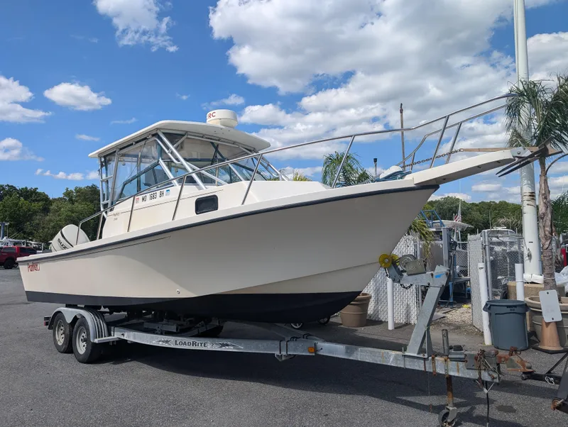 Slide: The Image of 1999 Parker 2510 Walkaround boat on a trailer in a marina. - 3