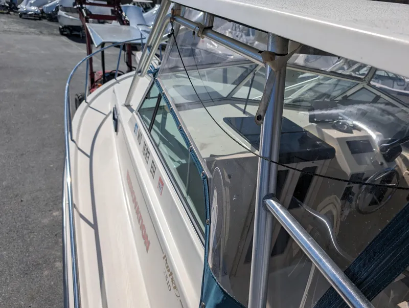 Slide: The Image of 1999 Parker 2510 Walkaround boat with windshield and railing, docked in a marina. - 32