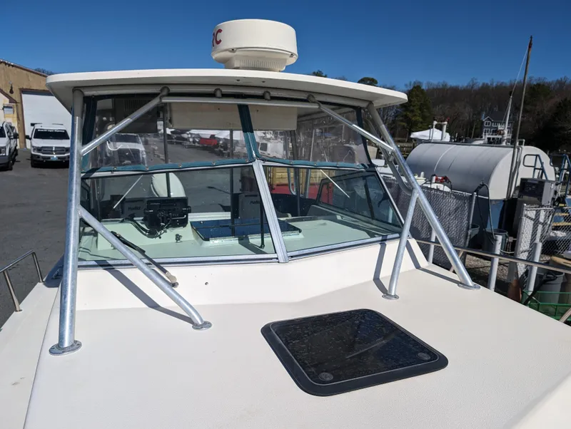 Slide: The Image of 1999 Parker 2510 Walkaround boat docked, front view with windshield and radar. - 35