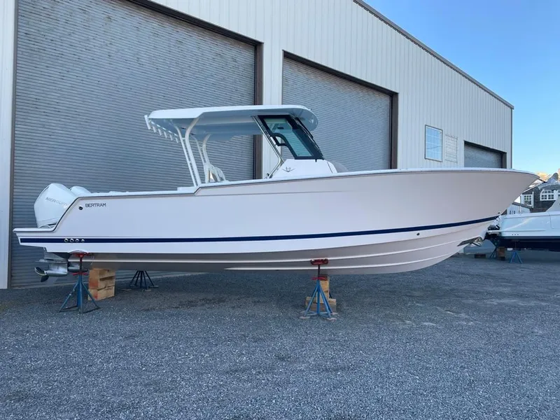 The Image of 2023 Bertram 28 CC boat on stands outside a warehouse. - 0