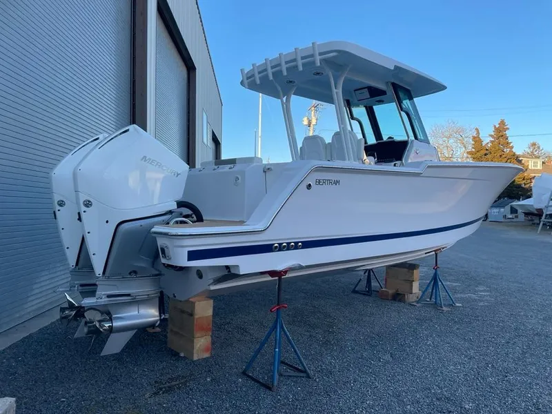 Slide: The Image of 2023 Bertram 28 CC boat on stands outside a warehouse. - 2