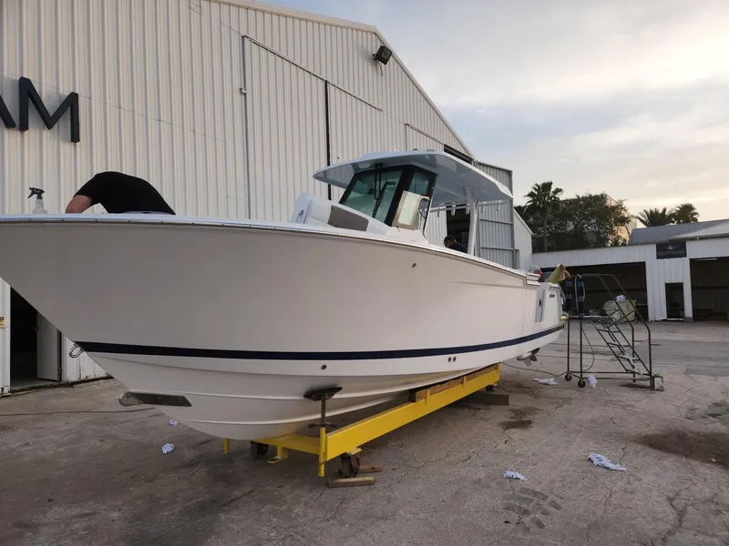 Slide: The Image of 2023 Bertram 28 CC boat on a yellow trailer outside a warehouse. - 6