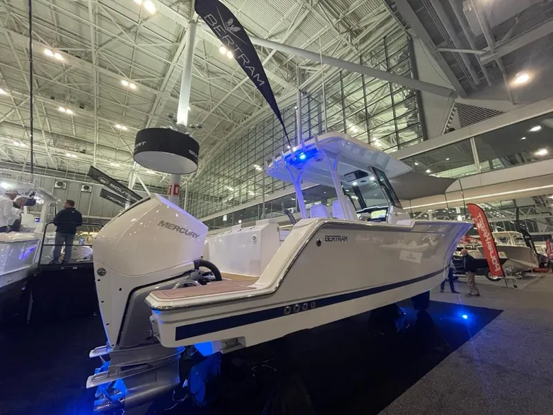 Slide: The Image of 2023 Bertram 28 CC boat on display at an indoor boat show. - 7