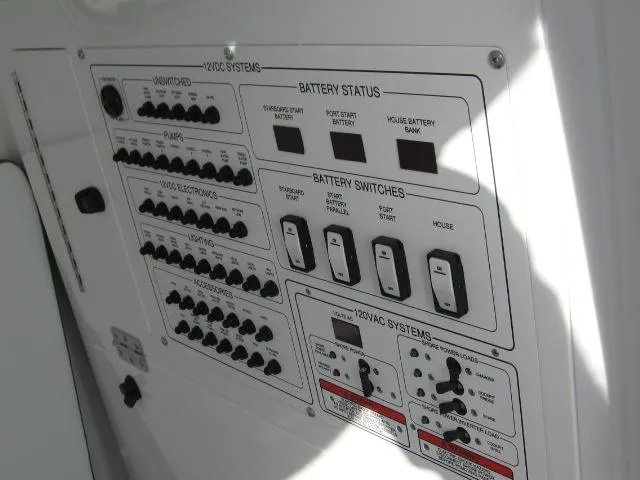 Slide: The Image of Control panel of a 2024 Edgewater 325 CC boat showing battery status and switches. - 12