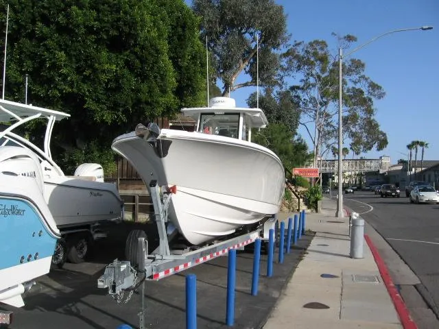 Slide: The Image of 2024 Edgewater 325 CC boat on a trailer in a parking lot. - 13