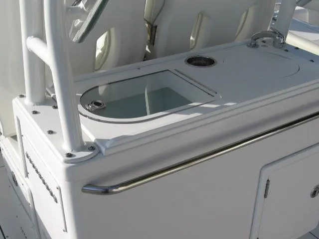 Slide: The Image of Edgewater 325 CC 2024 boat console with storage compartments and cup holder. - 5