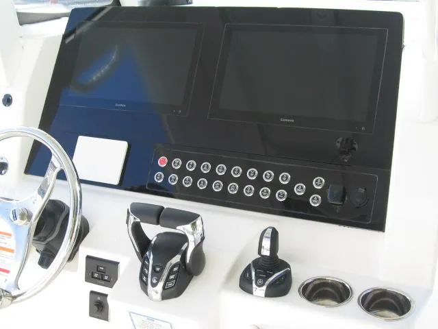 Slide: The Image of 2024 Edgewater 325 CC helm with dual Garmin displays and advanced controls. - 7