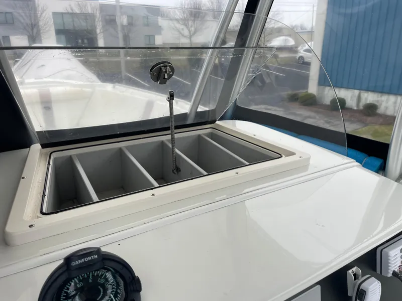 Slide: The Image of 2006 Sailfish 2360 CC boat console with storage compartments and compass. - 12