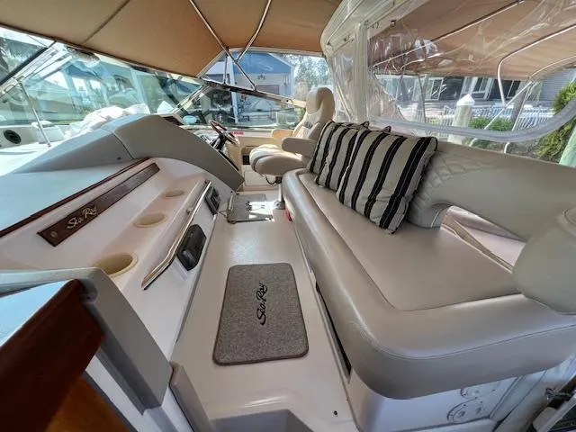 Slide: The Image of 1997 Sea Ray 500 Sundancer cockpit with beige seating and striped cushions. - 5