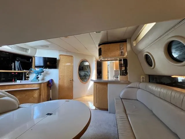 Slide: The Image of Interior of 1997 Sea Ray 500 Sundancer yacht with modern furnishings and circular windows. - 6