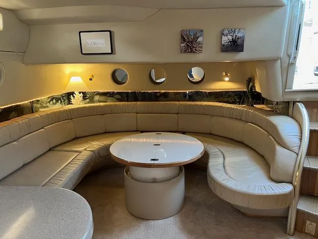 Slide: The Image of Interior of 1997 Sea Ray 500 Sundancer with curved leather seating and round table. - 7