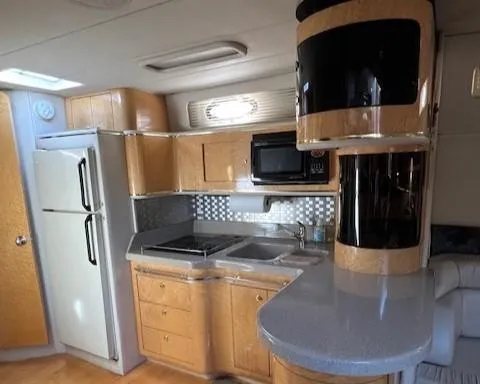 Slide: The Image of 1997 Sea Ray 500 Sundancer yacht kitchen with modern appliances and wooden cabinetry. - 8