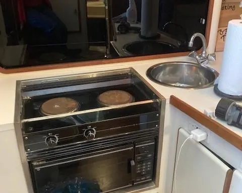 Slide: The Image of 1989 Tiara Yachts 3300 Open kitchen with stove, sink, and microwave. - 11