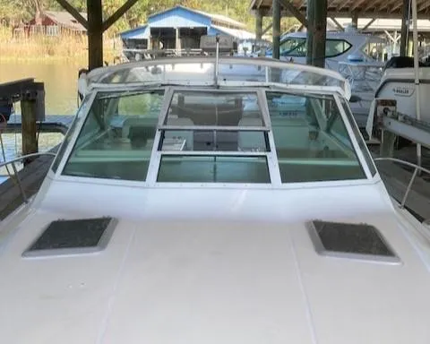 Slide: The Image of 1989 Tiara Yachts 3300 Open docked, front view of the boat's windshield and deck. - 7