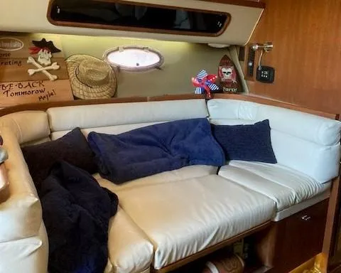 Slide: The Image of Cozy cabin interior of 1989 Tiara Yachts 3300 Open with white seating and nautical decor. - 9