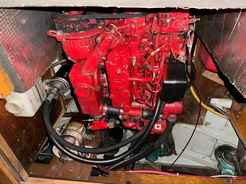 Slide: The Image of Engine compartment of a 1960 Concordia 39 Yawl, featuring a red marine engine. - 11