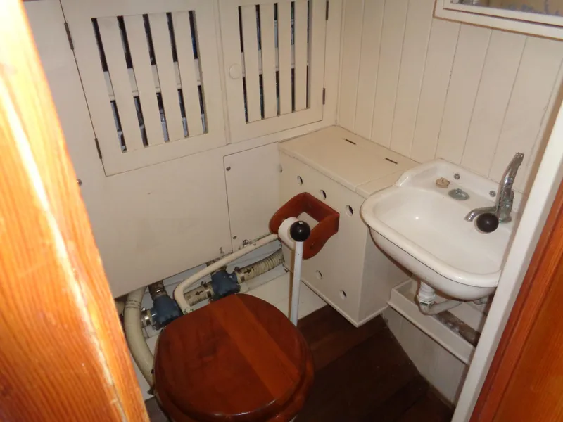 Slide: The Image of 1960 Concordia 39 Yawl bathroom with wooden toilet seat and compact sink. - 3