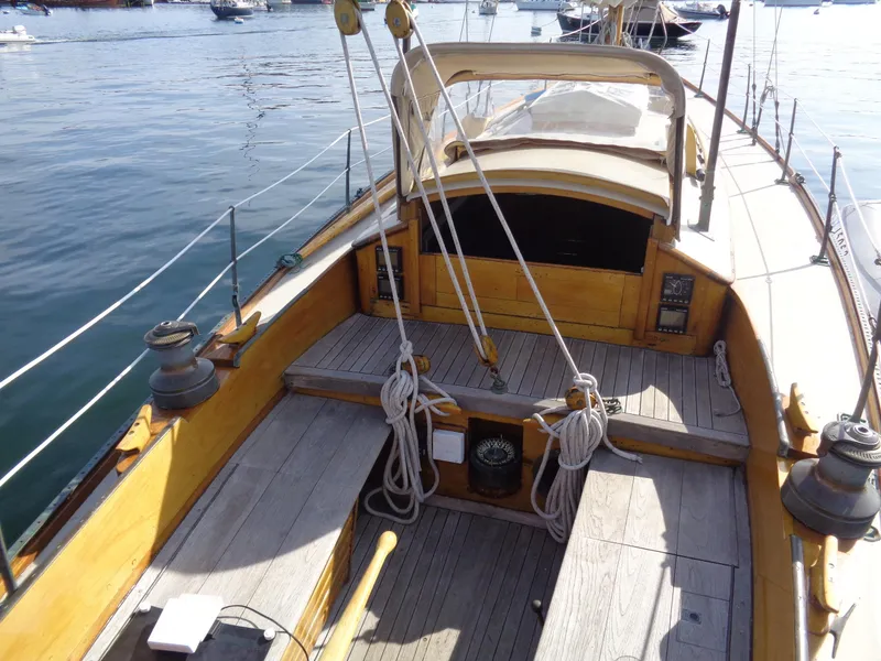 Slide: The Image of 1960 Concordia 39 Yawl sailboat deck with wooden finish and rigging, docked on calm water. - 8
