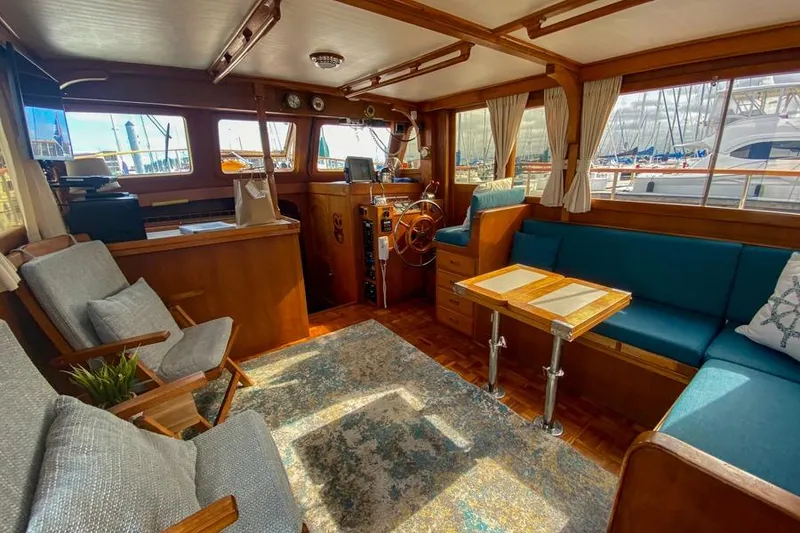 Slide: The Image of Interior of a 1980 CHB Trawler with wooden decor and blue seating. - 13