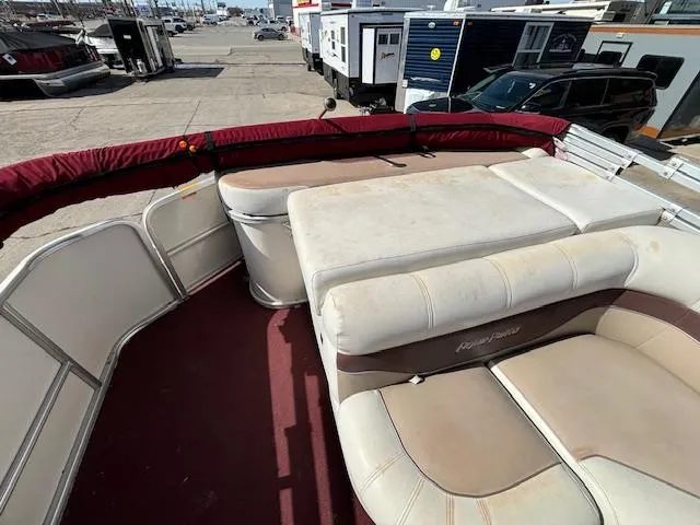 Slide: The Image of 2002 Godfrey Aqua Patio boat with worn seating and red carpet. - 11