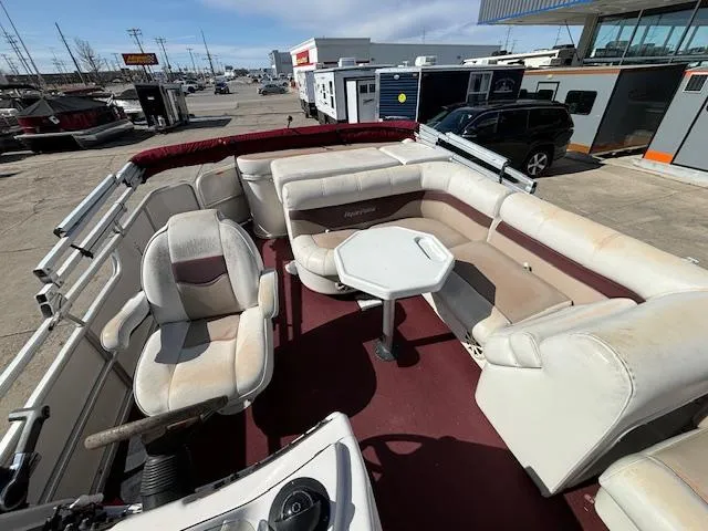 Slide: The Image of 2002 Godfrey Aqua Patio pontoon boat with seating and table, docked at a marina. - 9