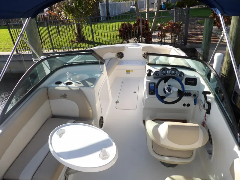 Slide: The Image of 2018 NauticStar 203DC Sport Deck boat interior with seating, steering console, and table. - 11