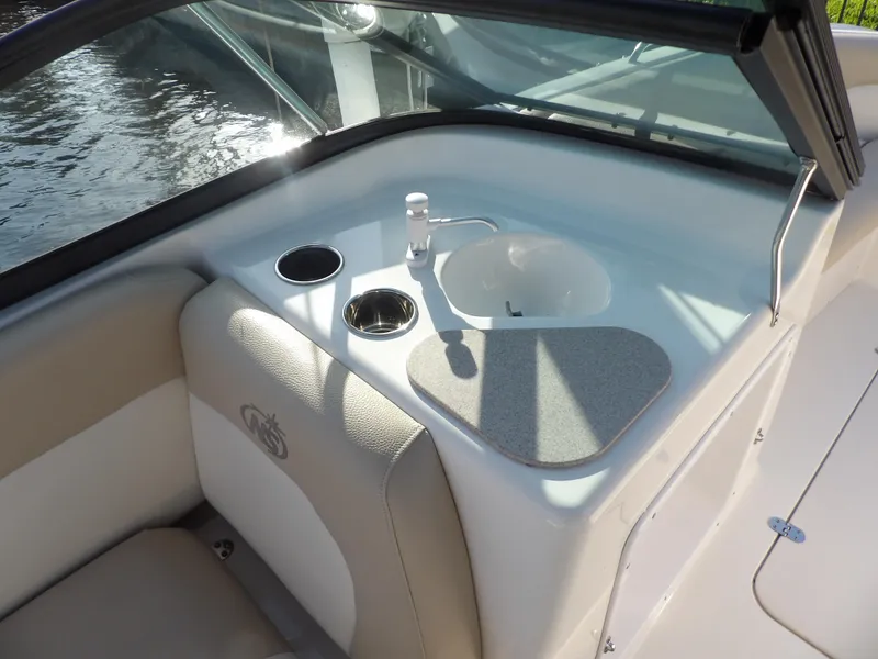 Slide: The Image of 2018 NauticStar 203DC Sport Deck boat interior with sink and cup holders. - 18