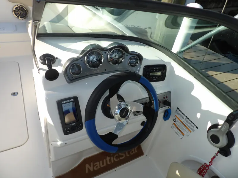 Slide: The Image of 2018 NauticStar 203DC Sport Deck boat dashboard with steering wheel and gauges. - 19