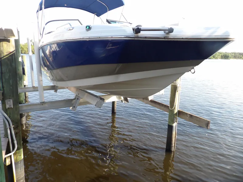 Slide: The Image of 2018 NauticStar 203DC Sport Deck boat on a lift over water. - 2