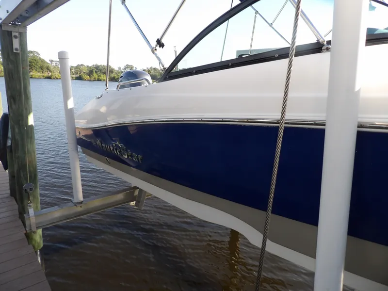 Slide: The Image of 2018 NauticStar 203DC Sport Deck boat docked on a lift. - 3